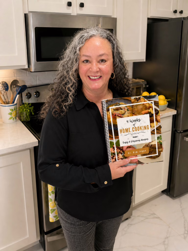 Dr. J holding her cookbook in her kitchen