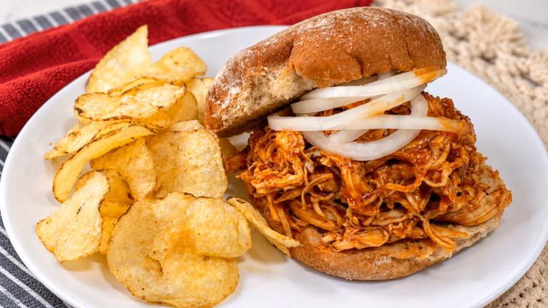 Instant Pot pulled BBQ chicken sandwich with pickled onion and potato chips.