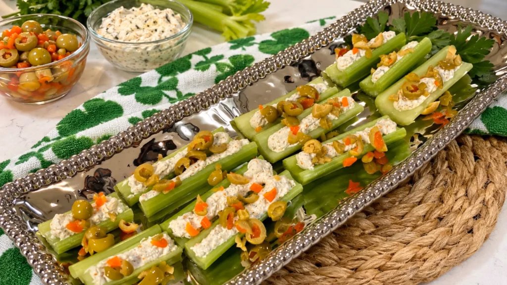 Celery sticks topped with cream cheese, feta, and pimento olive spread.
